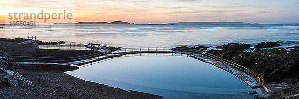 Guernsey Bathing Pools bei Sonnenaufgang mit Herm Island im Hintergrund  Kanalinseln  Vereinigtes Königreich