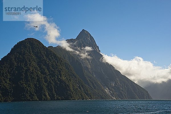 Touristenflug über Mitre Peak  Milford Sound  Südinsel  Neuseeland. Der Mitre Peak ist eine der beliebtesten Sehenswürdigkeiten am Milford Sound und erhebt sich 1692 m über dem Wasser. Wenn Ihr Budget es zulässt und das Wetter es erlaubt  bietet ein Flug über den Milford Sound einen unvergleichlichen Blick auf den Mitre Peak und die Umgebung.