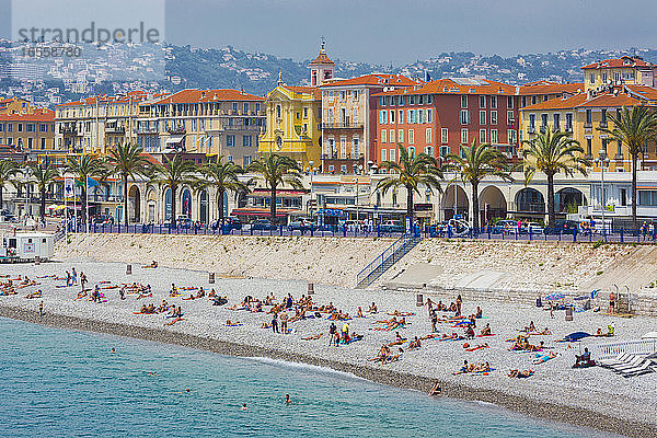 Nizza  Französische Riviera  Côte d'Azur  Frankreich. Badegäste am Strand vor der Promenade des Anglais. Vom Parc de la Colline du Chateau aus gesehen.