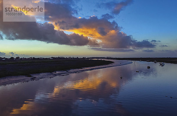 L'Aiguillon-sur-Mer  Departement Vendée  Pays de la Loire  Frankreich. Der Fluss Lay in der Nähe seiner Mündung in den Atlantischen Ozean. Sonnenuntergang. Die Wolken spiegeln sich im Wasser.
