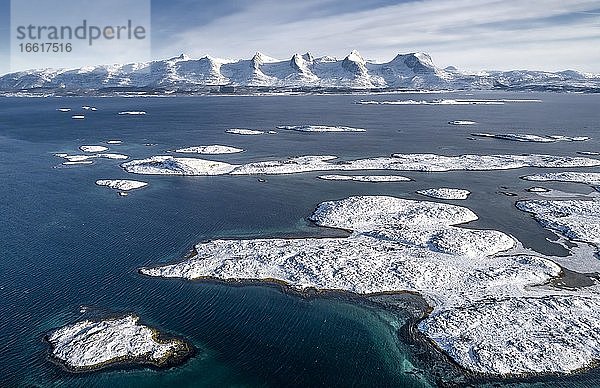 Verschneite Bergkette Sieben Schwestern (De syv søstre) (Sju søstre)  vorne winterliche Schären Inseln im Meer  Herøy  Nordland  Norwegen  Europa