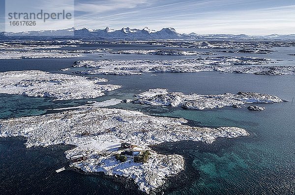 Verschneite Bergkette Sieben Schwestern (De syv søstre) (Sju søstre)  vorne winterliche Schären Inseln im Meer  Herøy  Nordland  Norwegen  Europa