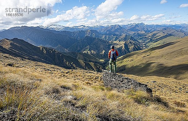 Wanderer steht auf Stein  Wanderweg zum Ben Lomond  Ausblick auf Berge  Südalpen  Otago  Südinsel  Neuseeland  Ozeanien