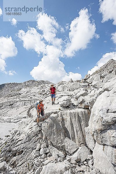 Zwei Wanderer in einer Landschaft aus ausgewaschenen Karststeinfelsen  Funtenseetauern  Steinernes Meer  Nationalpark Berchtesgaden  Berchtesgadener Land  Oberbayern  Bayern  Deutschland  Europa