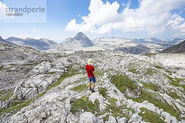 Wanderer blickt in die Ferne  Landschaft aus ausgewaschenen Karststeinfelsen  Funtenseetauern  Steinernes Meer  Nationalpark Berchtesgaden  Berchtesgadener Land  Oberbayern  Bayern  Deutschland  Europa