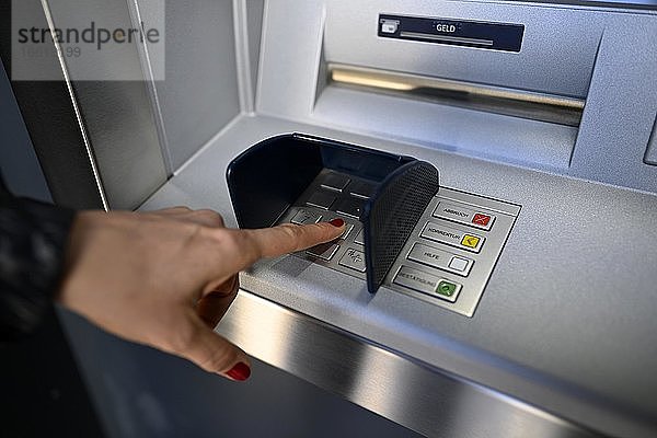 Frau tippt Geheimzahl am Geldautomat einer Sparkasse ein  Waiblingen  Baden-Württemberg  Deutschland  Europa