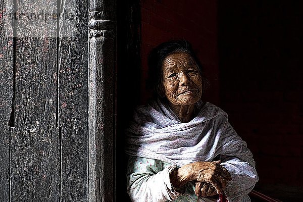 Porträt einer älteren Frau die aus einer Türöffnung herausschaut  Patan  Lalitpur  Kathmandu  Nepal  Asien