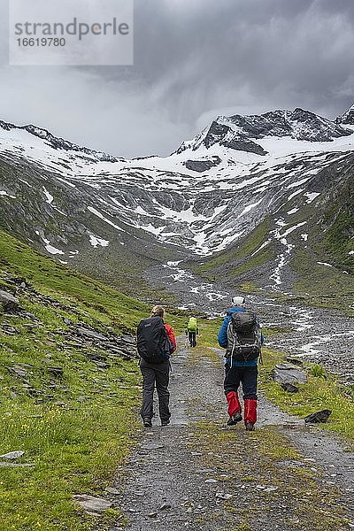 Wanderer im Tal bei schlechtem Wetter  hinten Gletscher Schlegeiskees  schneebedeckte Berggipfel  Hoher Weiszint  Berliner Höhenweg  Zillertal  Tirol  Österreich  Europa