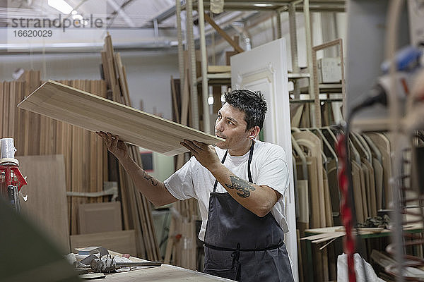 Künstler prüft Holz in der Werkstatt