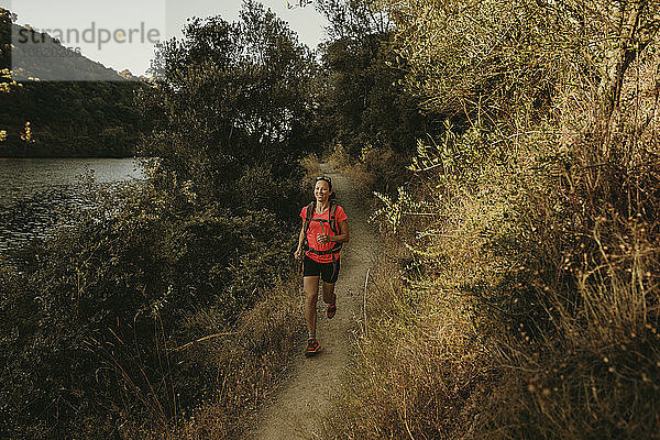 Lächelnde Frau  die auf einem Fußweg in der Sierra De Hornachuelos  Cordoba  Spanien  läuft