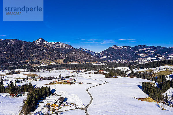 Österreich  Tirol  Kossen  Blick aus dem Hubschrauber auf das Bergdorf im verschneiten Leukental