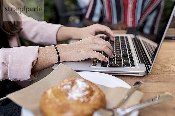 Geschäftsfrau arbeitet am Laptop am Tisch im Café