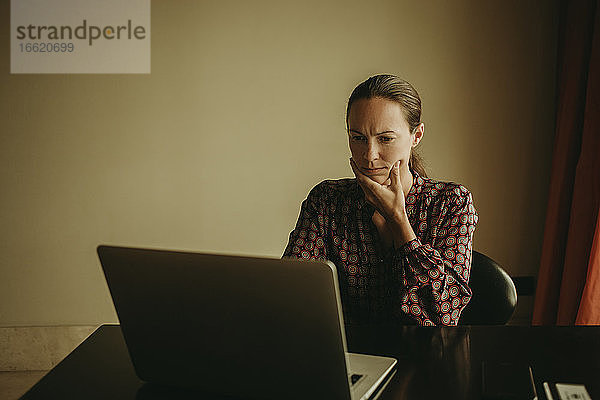 Seriöse Geschäftsfrau bei der Arbeit am Laptop im Büro