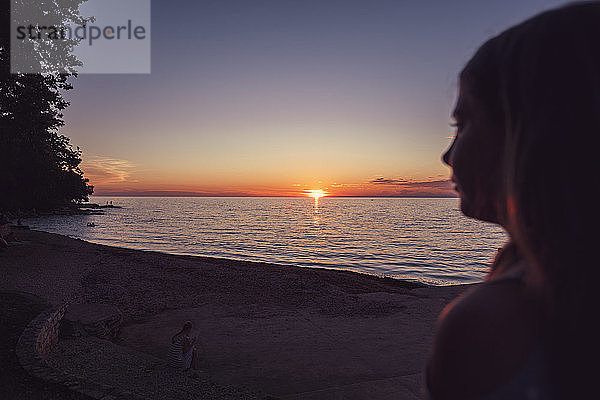 Mädchen beobachten den Sonnenuntergang über dem Adriatischen Meer  Novigrad  Kroatien