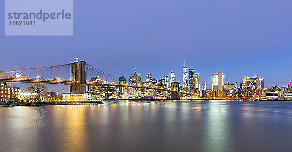 USA  New York  New York City  Brooklyn Bridge und Skyline von Manhattan bei Nacht beleuchtet