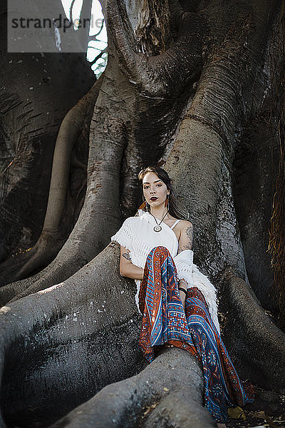 Frau  die unter einem Baum sitzt und sich ausruht