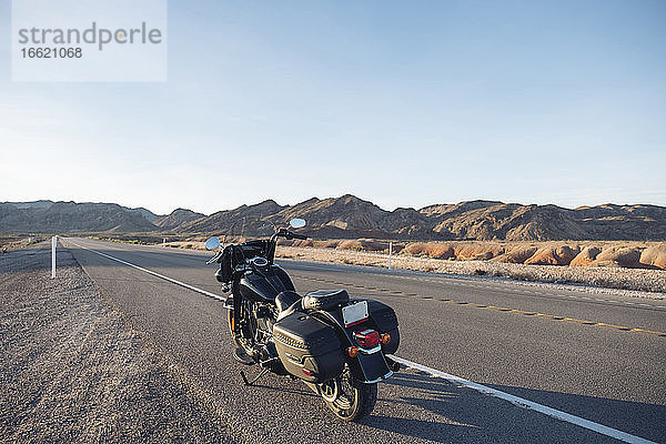 Motorrad auf Wüstenstraße gegen den Himmel geparkt  Nevada  USA