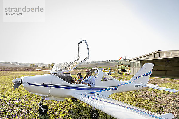 Enkelin und Großvater machen sich bereit  ein Flugzeug auf dem Flugplatz zu starten