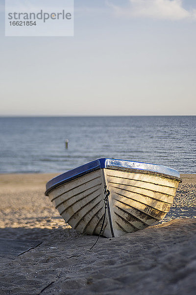 Boot in der Morgendämmerung am Sandstrand liegen gelassen