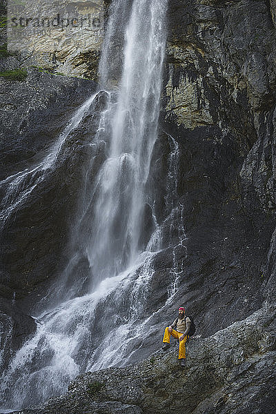 Älterer Mann sitzt auf einem Felsen vor einem Wasserfall  Otscher  Österreich