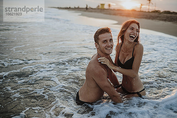 Glückliches Paar genießt im Wasser am Strand