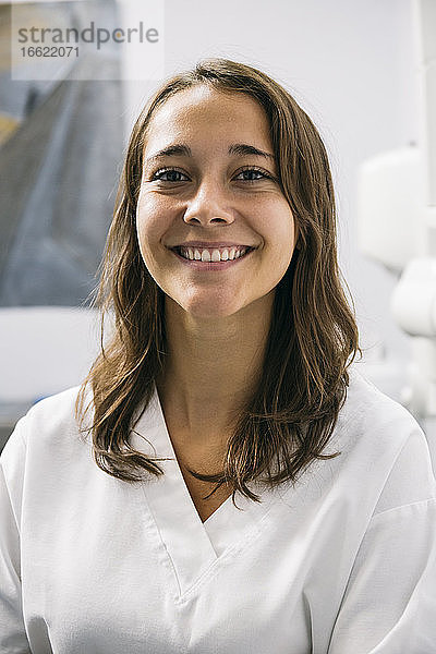 Lächelnde schöne weibliche Zahnarzthelferin in einer Zahnklinik