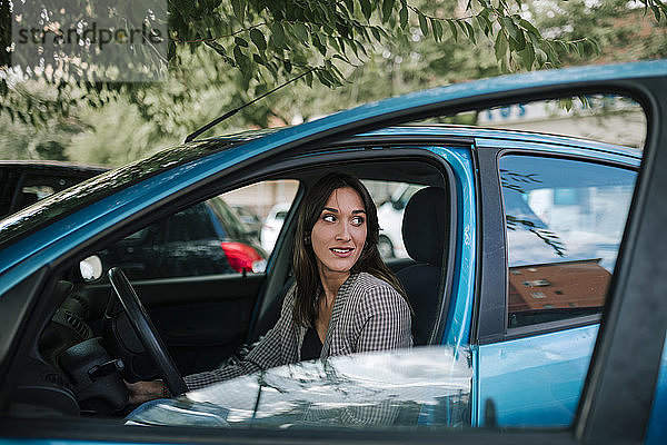 Junge Frau schaut weg  während sie im Auto sitzt