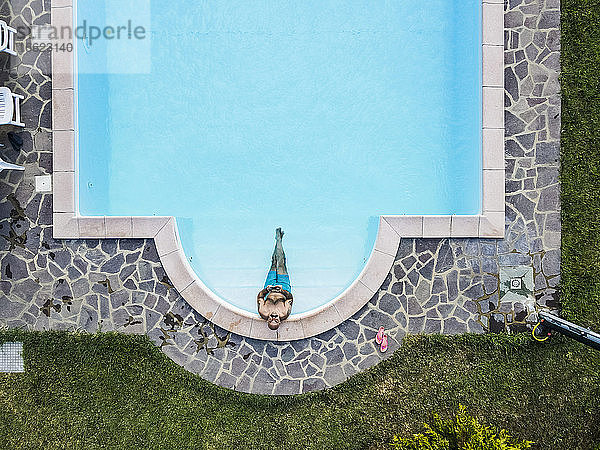 Drohnenansicht eines Mannes beim Entspannen im Schwimmbad