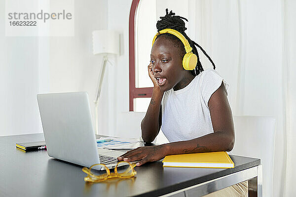 Geschäftsfrau bei einer Videokonferenz über einen Laptop auf dem Schreibtisch im Heimbüro