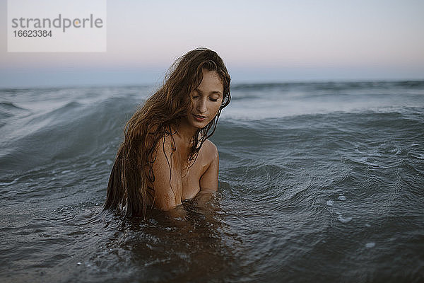Junge Frau genießt im Wasser am Strand