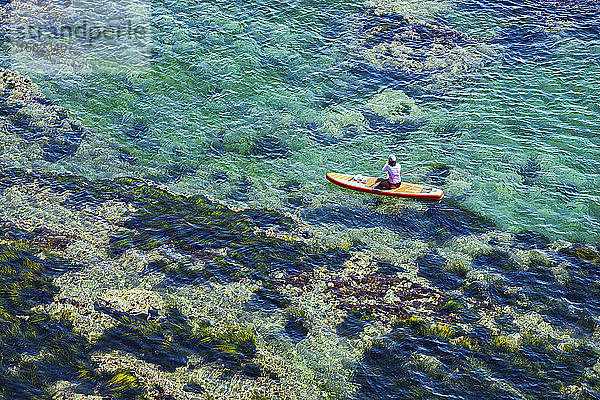 Luftaufnahme von Frau Paddleboarding im klaren Wasser der Lukin Bucht