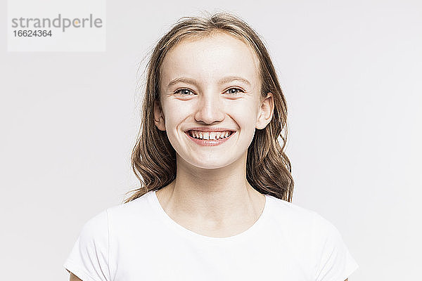Nahaufnahme eines niedlichen lächelnden Mädchens vor weißem Hintergrund