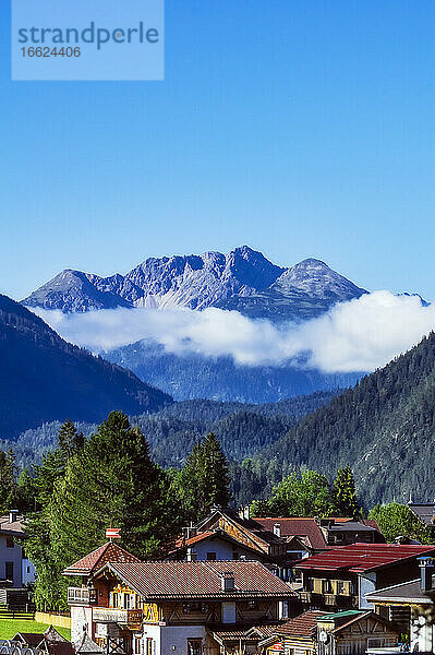 Österreich  Tirol  Ehrwald  Häuser eines Bergdorfes mit bewaldetem Tal und Zugspitze im Hintergrund