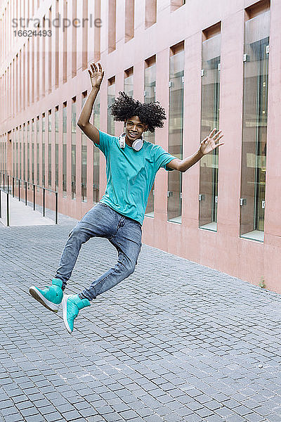 Junger Mann springt auf der Straße in der Stadt