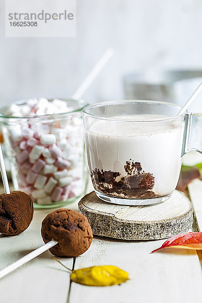 Nahaufnahme von heißer Schokolade mit Marshmallows und Trüffel-Lutschern auf dem Tisch zu Hause
