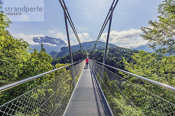 Österreich  Tirol  Reutte  Frau steht in der Mitte der Highline179 an einem sonnigen Tag