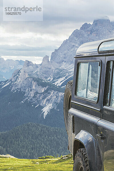 Geländewagen gegen Berggipfel von Sexten  Dolomiten  Südtirol  Italien aus gesehen