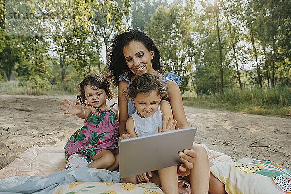 Mutter und Töchter führen einen Videoanruf auf einem digitalen Tablet