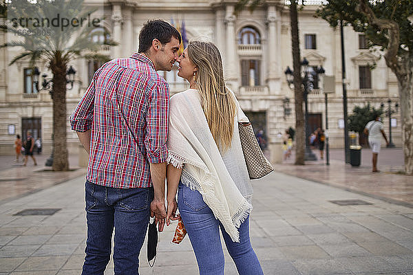 Paar kuschelt sich an die Nase  während es in der Stadt steht