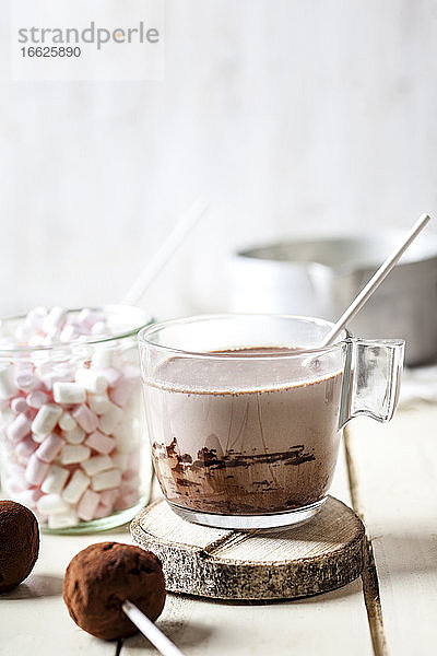Heiße Schokolade mit Trüffel-Lutschern und Marshmallows auf dem Tisch zu Hause