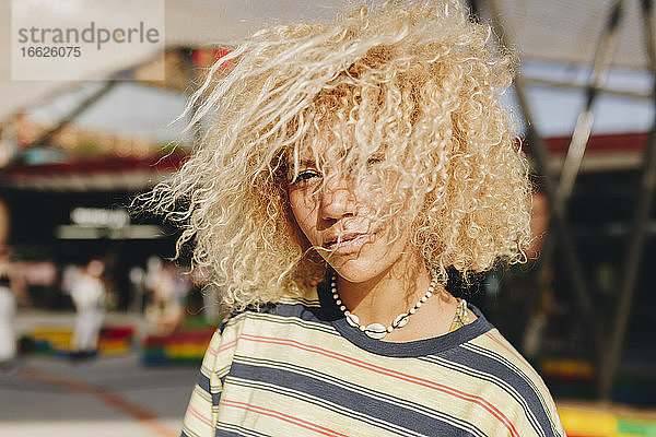 Selbstbewusste blonde Afro-Frau  die an einem sonnigen Tag im Freien steht