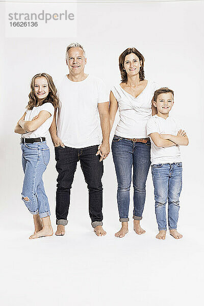 Lächelnde Familie stehend vor weißem Hintergrund