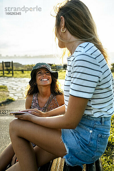 Lächelnde junge Frauen  die sich unterhalten  während sie ein Wochenende zusammen verbringen