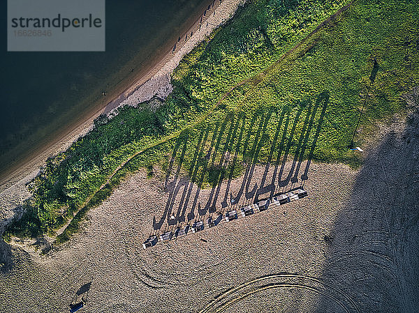 Strand mit langem Schatten bei Sonnenuntergang von oben gesehen