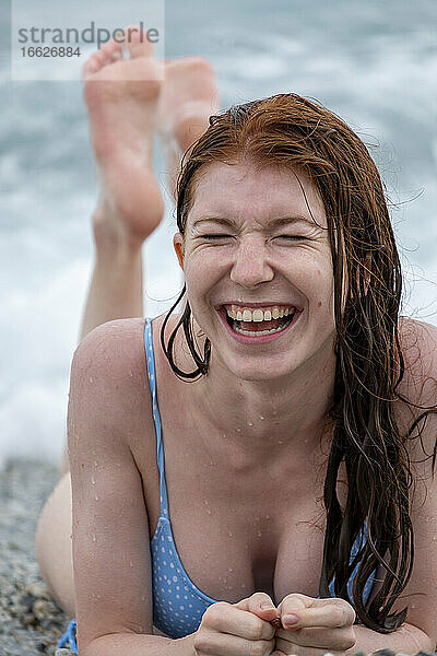 Schöne junge Frau im Bikini am Strand liegend