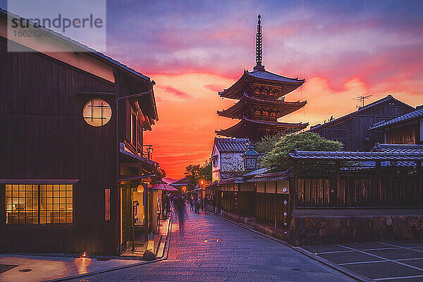 Antiker Tempel an einer traditionellen Straße bei bewölktem Himmel während des Sonnenuntergangs  Kyoto