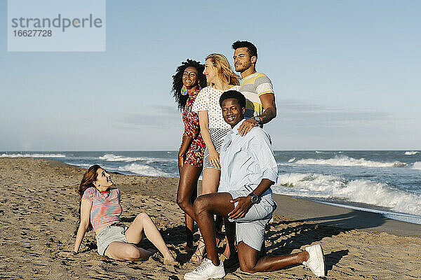 Glückliche junge Freunde verbringen ihre Freizeit am Strand während eines sonnigen Tages