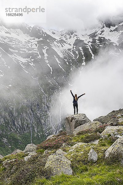 Berglandschaft bei Nebel  Wanderin streckt Arme in die Luft  nahe Furtschaglhaus  Berliner Höhenweg  Zillertaler Alpen  Zillertal  Tirol  Österreich  Europa