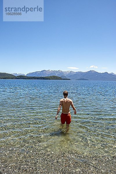 Junger Mann badet im See  Lake Manapouri  Frasers Beach  Manapouri  Südinsel  Neuseeland  Ozeanien
