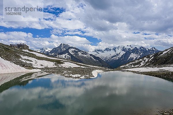 Friesenbergsee mit Friesenberghaus vor schneebedeckten Bergen  Mitte Großer Greiner  rechts Hochsteller  Zillertaler Alpen  Zillertal  Tirol  Österreich  Europa